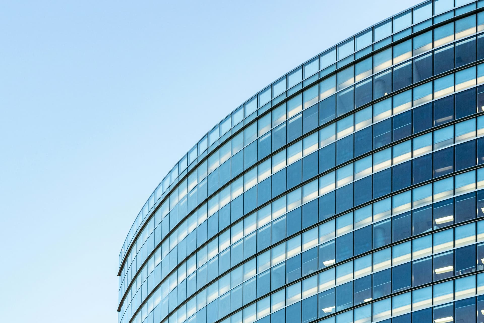 Façade vitrée courbe sous un ciel clair
